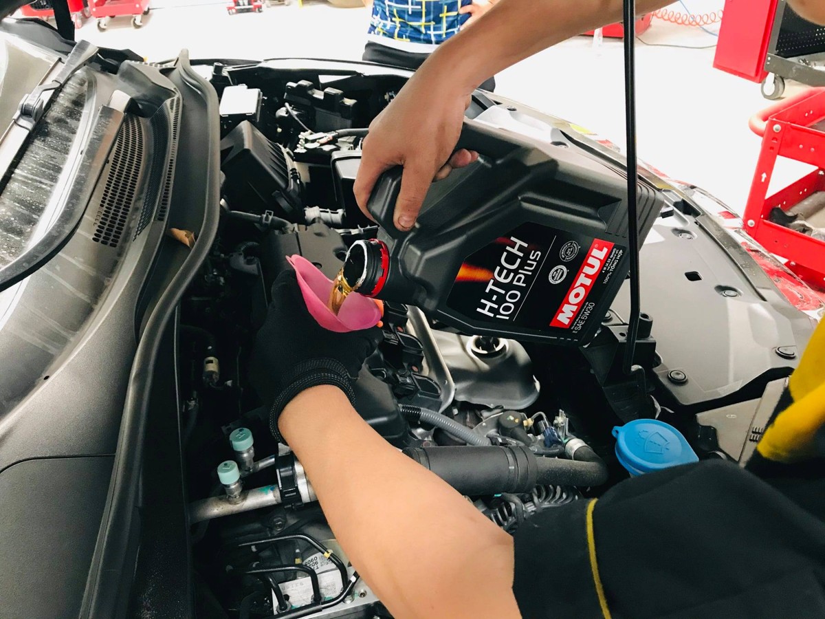Đổ nhớt Motul H-Tech 100 Plus 5W-30 vào động cơ tại xưởng
